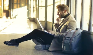 Poza de cover  Importanta asigurarii de calatorie in strainatate Ce trebuie sa stii inainte de a pleca Barbat, aeroport, coridor, laptop, rucsac jpg