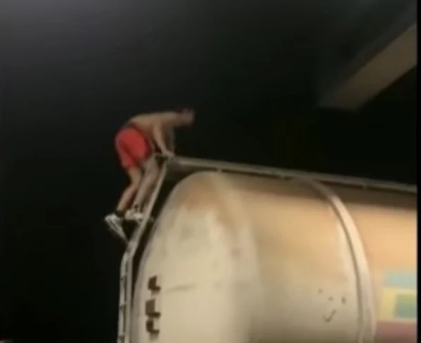 Tânărul în timp ce se urcă pe un vagon de tren