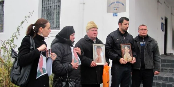 Familiile îndioliate au protestat ţinând în mâini tablourile celor decedaţi în spitalele din Craiova. Foto: G.P. 