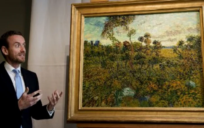 Axel Rueger, directorul Muzeului „Van Gogh“ din Amsterdam, prezentând tabloul pictorului olandez, „Apus de soare la Montmajour“ FOTO: Huffington Post