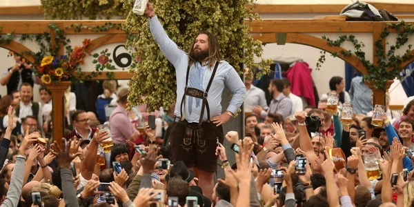 Vizitatorii ţin în mână halbe de bere de un litru în onoarea deschiderii Oktoberfest în Munchen. FOTO Guliver/Gettyimages