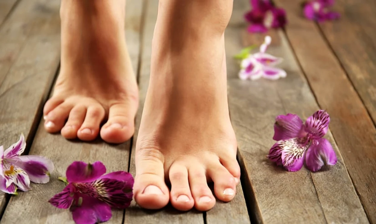 Picioare frumoase care merg printre flori aruncate pe o podea Foto Feet First Clinic