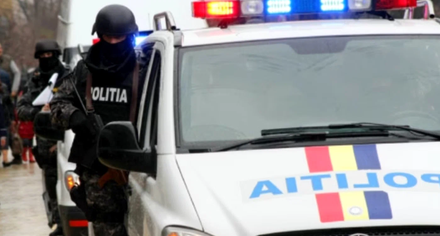 Polițiști cu cagule lângă o mașină de poliție