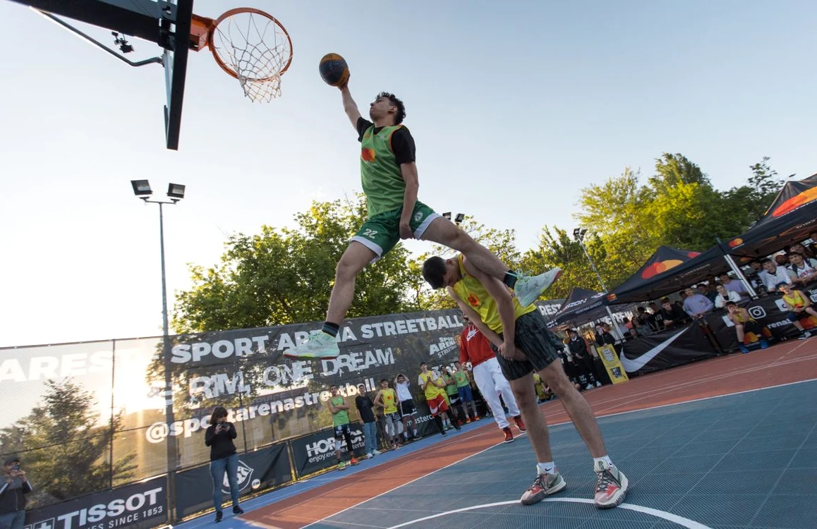 Baschetbalist înscrie un slam dunk sărind peste un coechipier