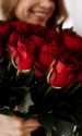 femeie zambitoare buchet trandafiri rosii jpg