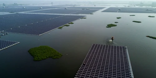 O barcă trage un grup de panouri solare care urmează să fie conectate la proiectul unei ferme solare plutitoare construit de compania de Sungrow Power Supply pe un lac în Huainan provincia Anhui China FOTO Guliver / Getty Images / Kevin Frayer