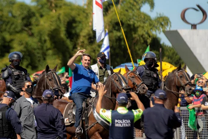 Preşedintele Braziliei Jair Bolsonaro şi-a întâmpinat călare miile de suporteri, ignorând regulile de distanţare socială. FOTO EPA