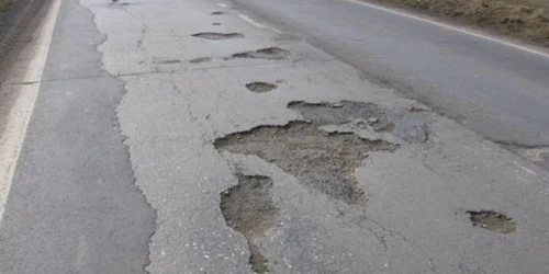 Drumul este plin de gropi. FOTOArhivă.