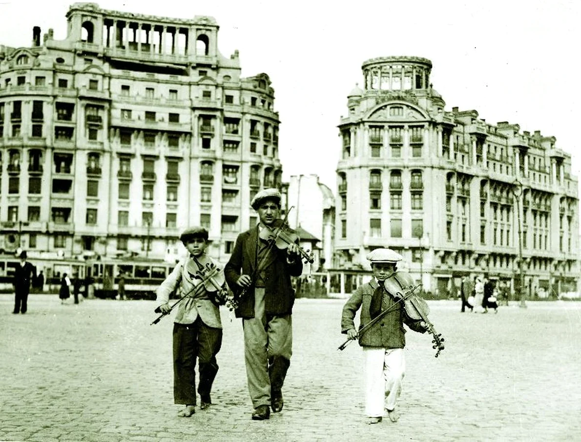 Copii cântând la vioară în centrul Bucureştiului în perioada interbelică. Fotografie de Iosif Berman 