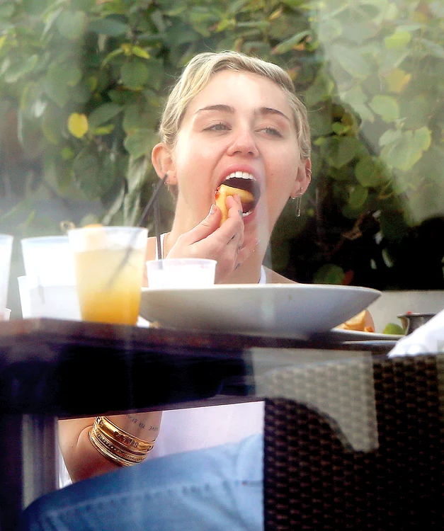 
    Miley Cyrus (22 de ani)  îndeasă dumicatul până  în amigdale  