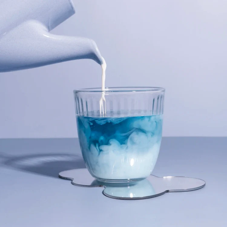 Cineva toarnă lapte peste blue matcha