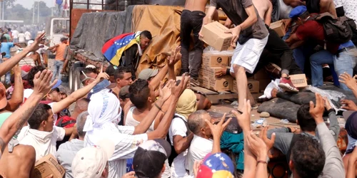 Imaginea Zilei / Zeci de oameni vor să primească ajutoare umanitare încărcate într-un camion care a fost oprit în Ureña Venezuela FOTO EPA – EFE / Deibison Torrado / 24 feb 2019