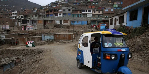 Un taxi motocicleta duce pasageri într-un cartier sărac din Lima Peru FOTO AP