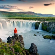 Turist care admiră cascada Goðafoss FOTO Shutterstock