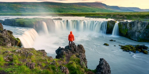 Turist care admiră cascada Goðafoss FOTO Shutterstock
