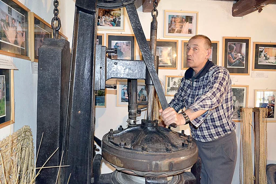 Ghidul Szocs Lajos le  explică vizitatorilor cum se  confecţionează pălăriile