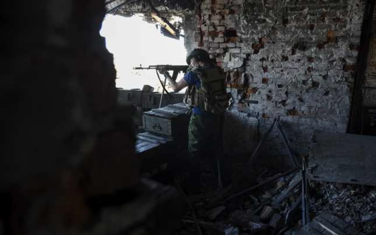 Un rebel pro-rus trage către poziţiile armatei ucrainene de pe aeroportul Doneţk estul Ucrainei FOTO AP