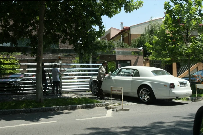 Milionarul și al său Rolls Royce Phantom Coupe (500.000 de euro). În plan secund se vede cum trecătorii se uită în curte ca la mașini străine