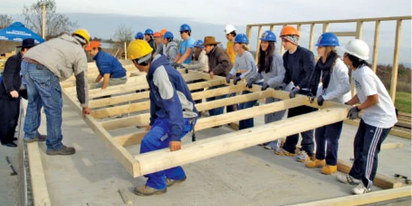 Tinerii îndrumaţi de profesionişti învaţă să ridice o casă de la fundaţie la acoperiş