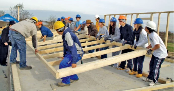 Tinerii îndrumaţi de profesionişti învaţă să ridice o casă de la fundaţie  la acoperiş 