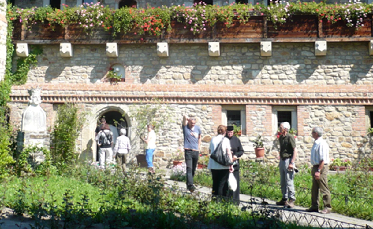 Turiştii sunt ghidaţi de o măicuţă în curtea de la Suceviţa