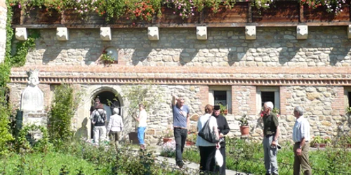 Turiştii sunt ghidaţi de o măicuţă în curtea de la Suceviţa