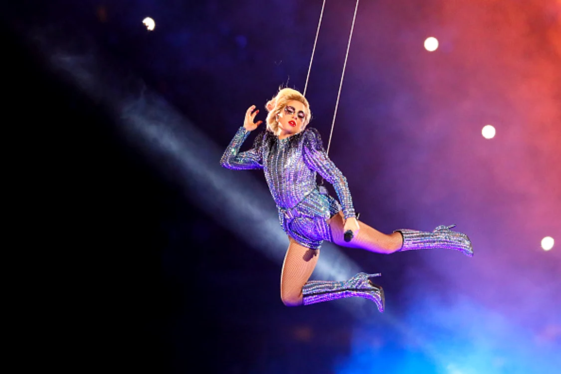 
    Lady Gaga își execută perfect acrobațiile, însă un fan a făcut-o să cadă de pe scenă, la propriuFoto: Getty   