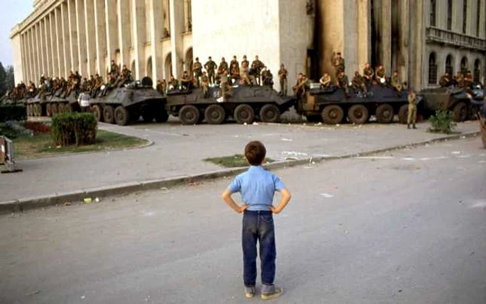 Băiat stând în faţa Armatei şi a tancurilor în Bucureşti, România. FOTO Guliver/GettyImages