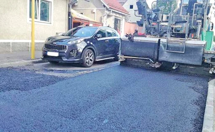 
    Muncitorii au turnat asfalt  în jurul mașinii al cărei proprietar nu a fost de găsit  