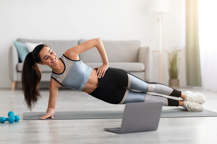 Tânără care face exerciții Pilates în confortul casei sale