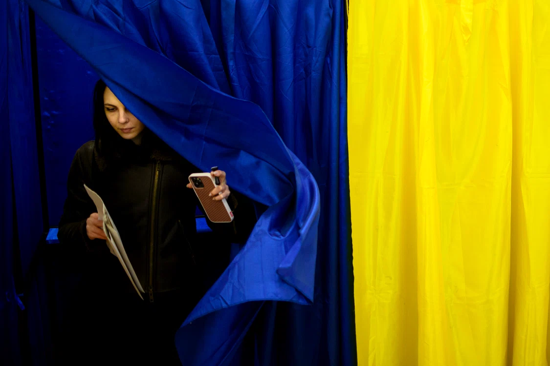 Tânără româncă ieșind din cabina de vot 