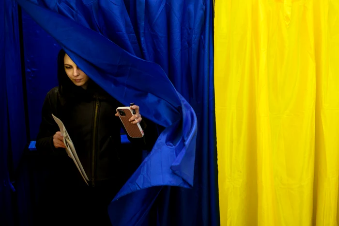 Tânără româncă ieșind din cabina de vot 