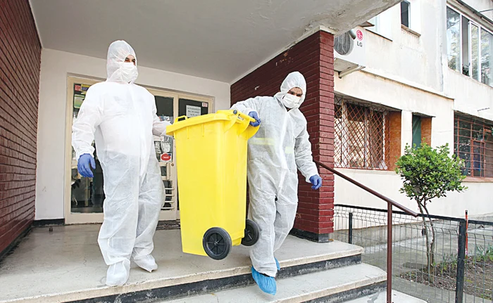 Andrei și Florică poartă mască, costum de protecție și mănușiFoto: Sever Gheorghe