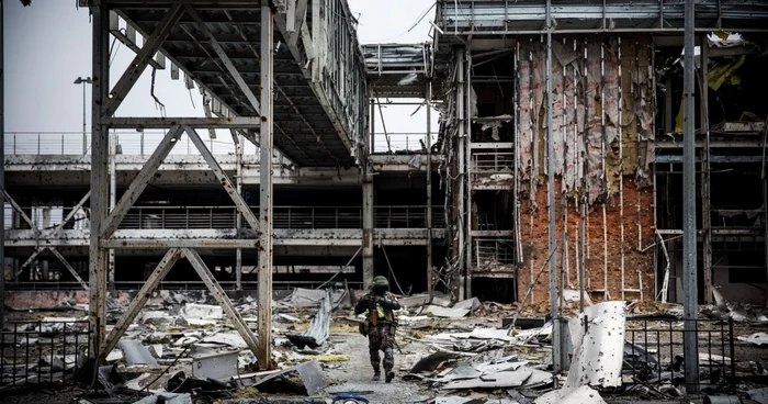 Un rebel prorus se plimbă prin ruinele aeroportului din Doneţk