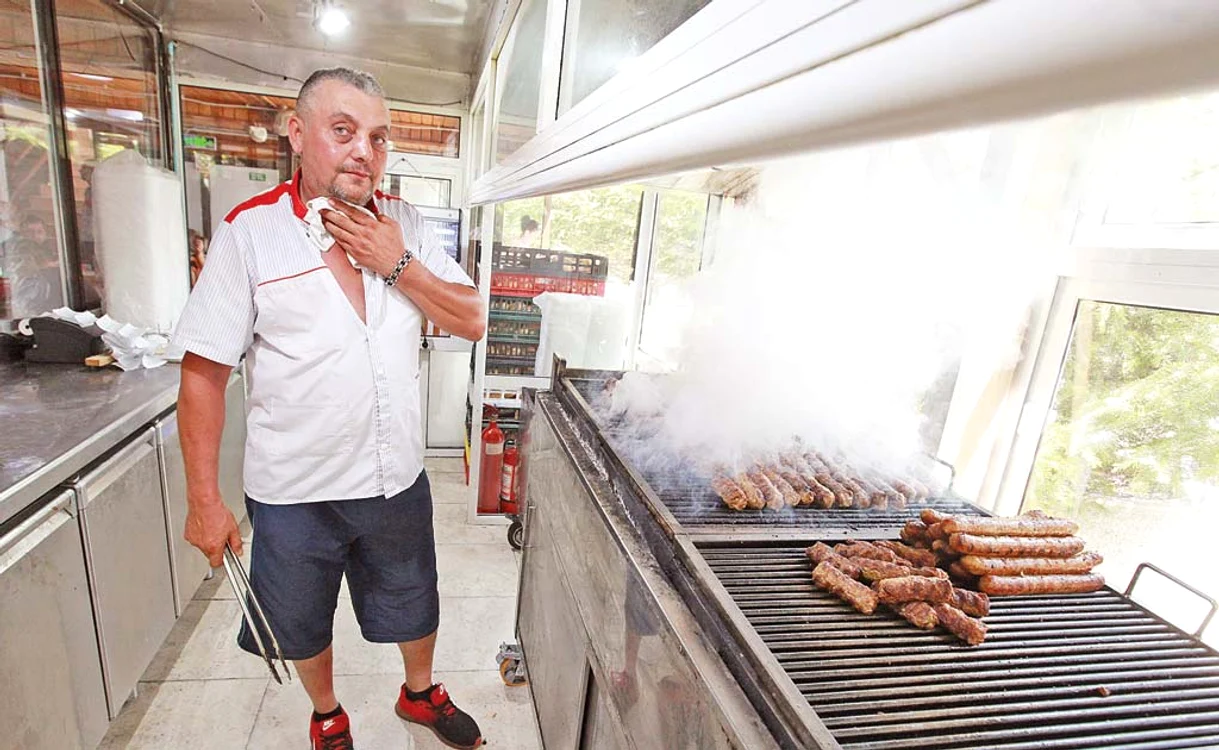 Bucătarul Vasile Roșu a pregătit ieri pe caniculă în jur de 1.000 de mici și 90 de cârnați pentru cei care s-au înghesuit ieri la terasa din BrăneştiFoto: Sever Gheorghe