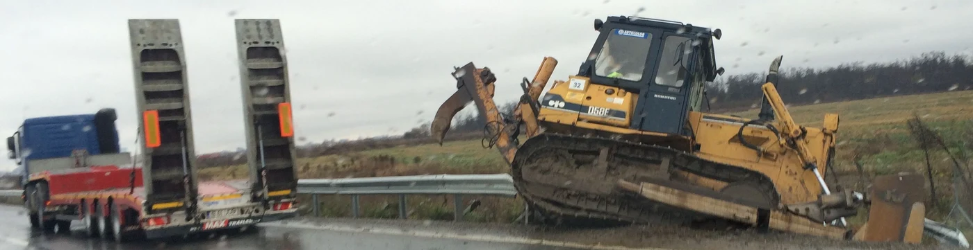 Buldozerul a căzut de pe autotrailer direct într-un șanț