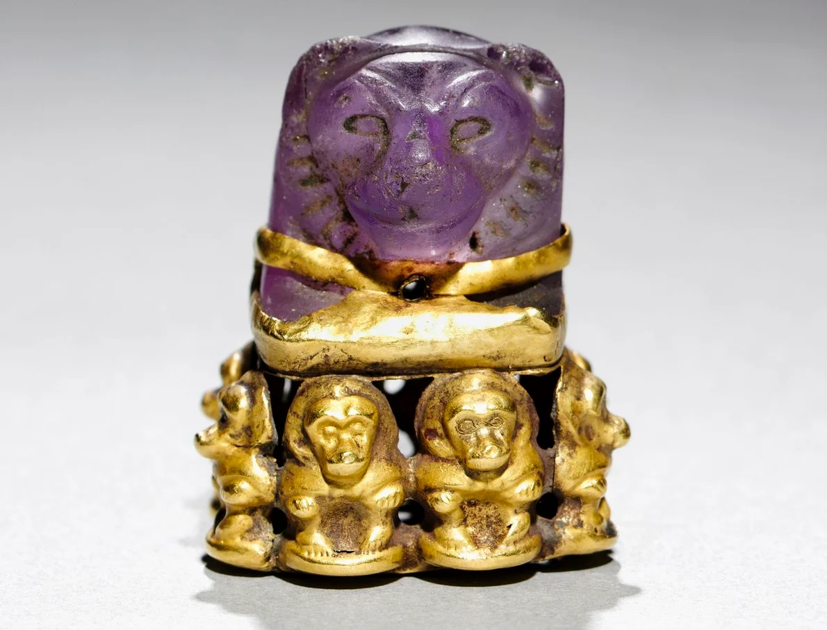 Pandantiv cu cap de leu montat pe o bază de aur decorată cu babuini (© Cleveland Museum of Art)