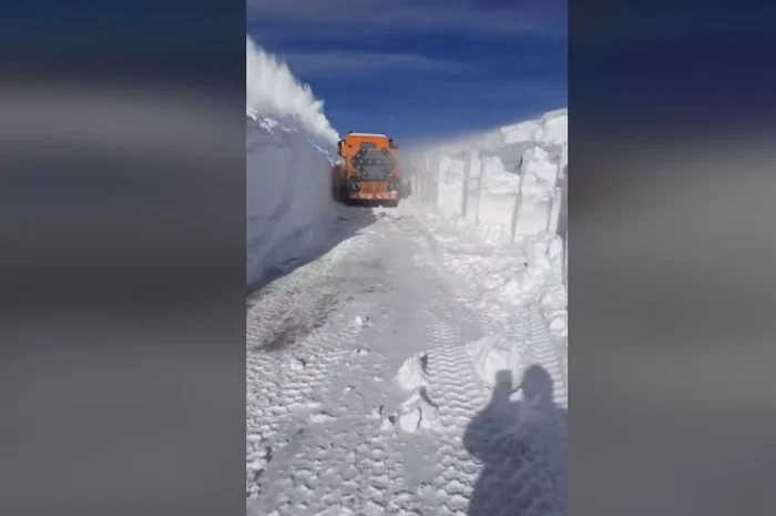 Îndepărtare de pe partea carosabilă a zăpezii viscolite noaptea trecută pe DN 67C, stațiunea Rânca, ieșirea spre Transalpina.Foto: captură video