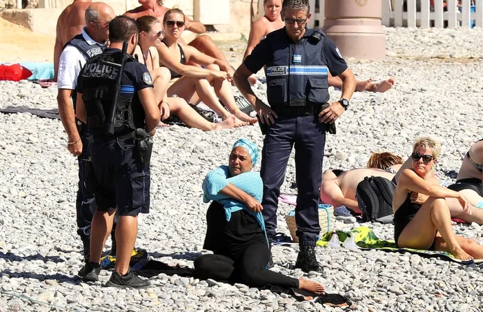 Poliţişti din Nisa amendand o femeie ce purta burkini pe plajă FOTO AFP