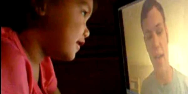 Fetiţa se uită la monitorul pe care a apărut tatăl ei