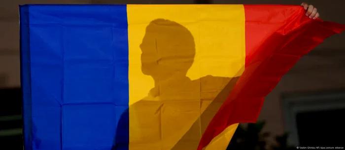 Un susținător AUR cu drapelul României după anunțarea rezultatelor alegerilor europarlamentare 2024