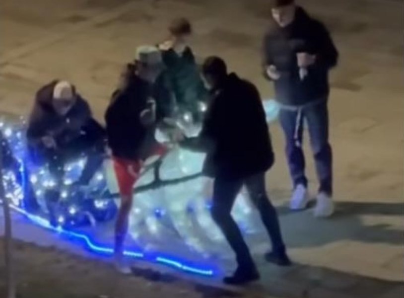 Filmare vulgară la un târg de Crăciun din România: sex mimat cu renii şi urinat lângă drapel 