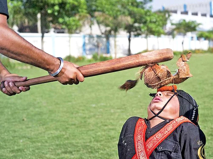 
    Nuca de cocos  este spartă pe  ţeasta lui cu o  bâtă de baseball  