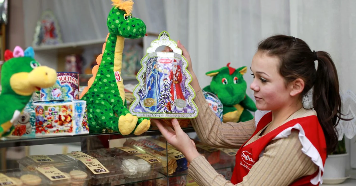 Vânzătorii de dulciuri aranjează jucăriile pe rafturi