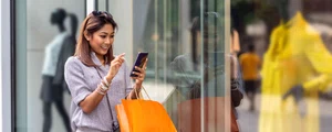 asian woman using the smart mobile phone for check online shopping order is completed with clothes beside the glassess in store shop with happy action at department center 961515078 d885f0506450479c9efb38d9ddf1ed58 jpg