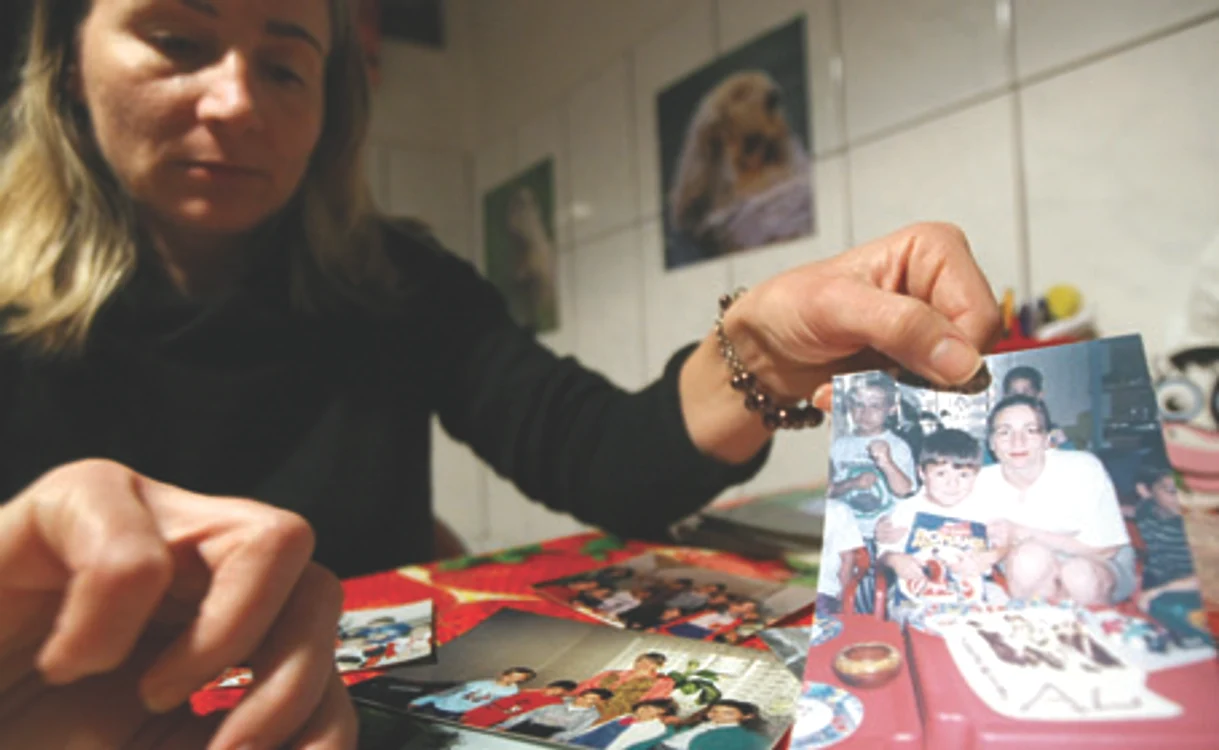 Gabriella Pavel răsfoieşte fotografiile cu micuţii care au învăţat la grădiniţa din sufragerie