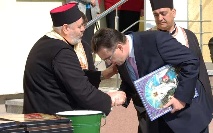 Marian Oprişan, sărutând mâna preotului la o sfinţire a unei instituţii