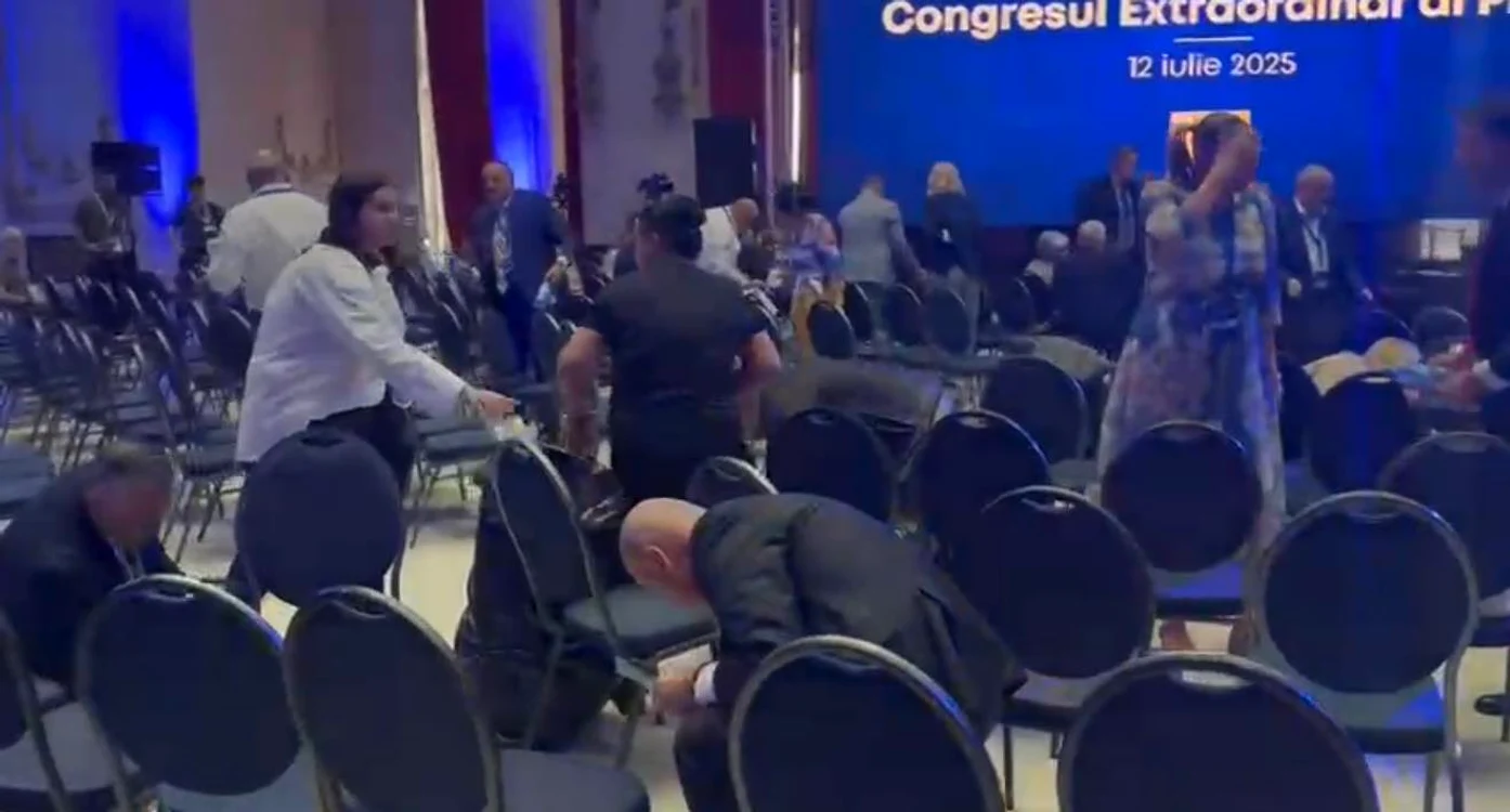 Premierul Ilie Bolojan, strângând gunoaiele din sala Congresului PNL. Sursă foto: captură video