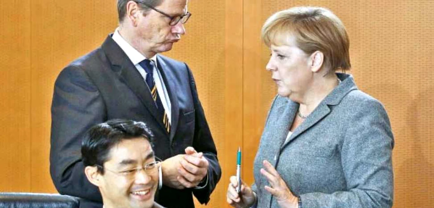 Cancelarul german, Angela Merkel, pune ţara la cale împreună cu ministrul de Externe, Guido Westerwelle, şi cu ministrul Economiei, Philipp Roesler (jos)