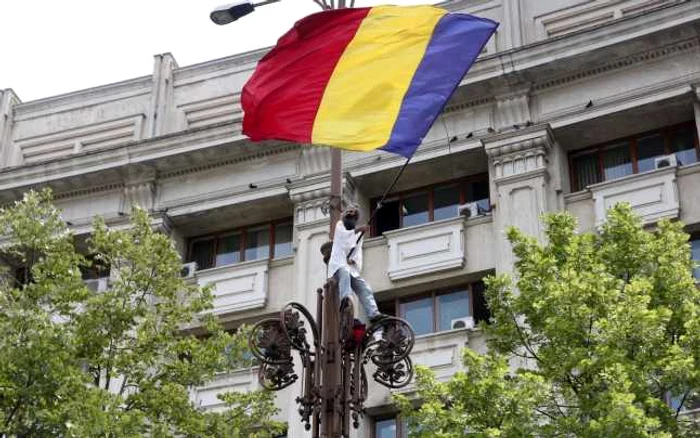 Un bărbat s-a urcat pe un stâlp de iluminat din apropierea Parlamentului FOTO Mediafax